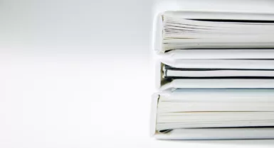A stack of thick folders on a white surface